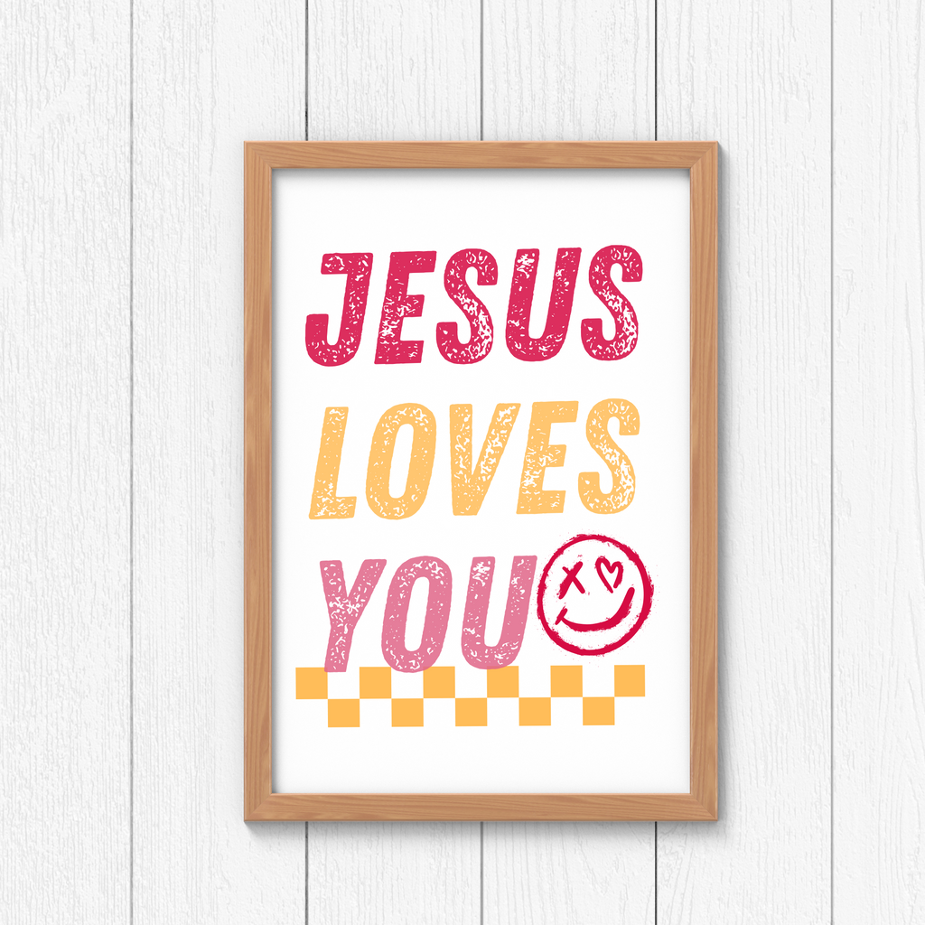 Framed wall art sign reading “JESUS LOVES YOU” in pink, orange, and red.