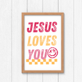 Framed wall art sign reading “JESUS LOVES YOU” in pink, orange, and red.