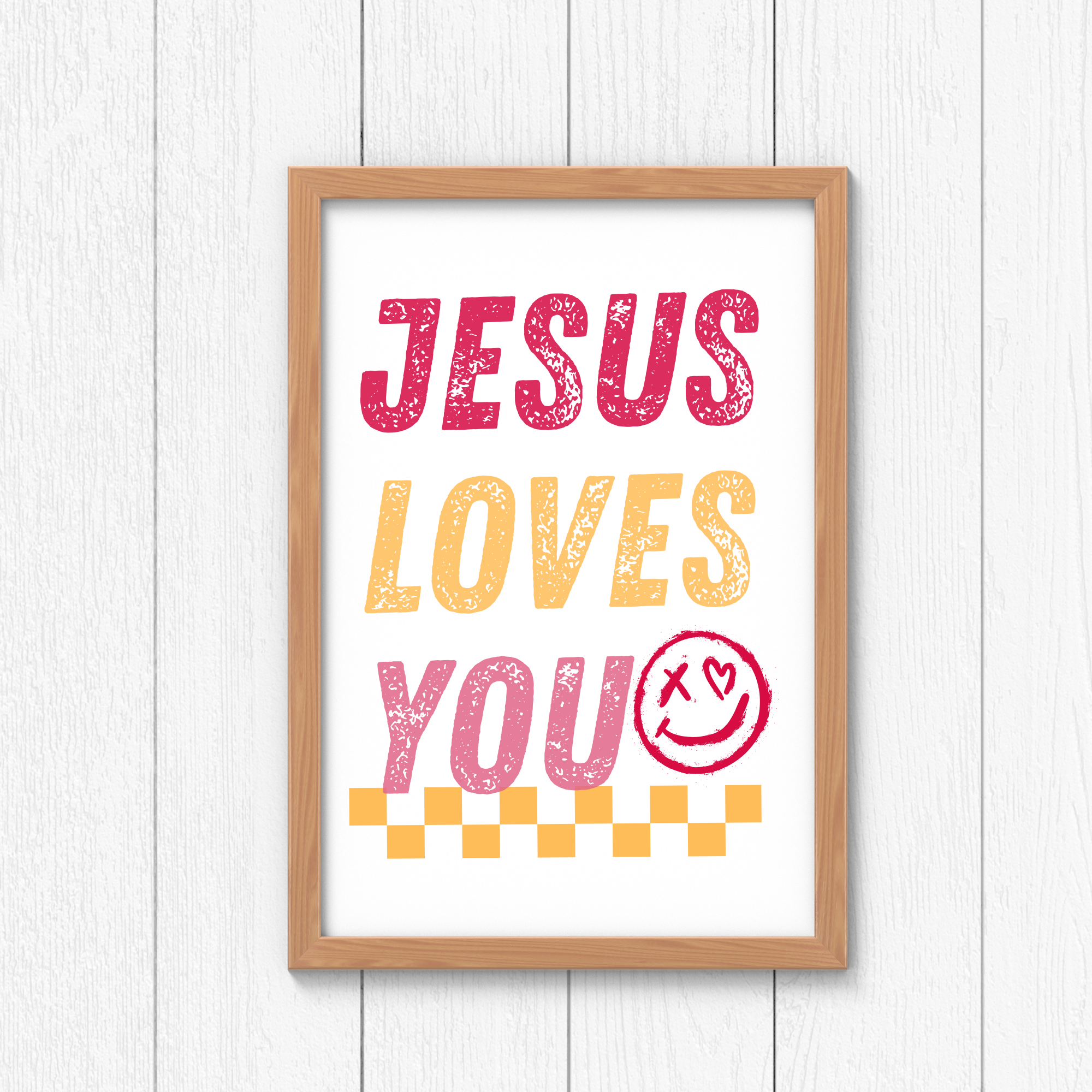 Framed wall art sign reading “JESUS LOVES YOU” in pink, orange, and red.