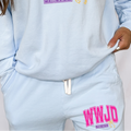 Light blue sweatpants with drawstring waist and pink “WWJD” logo on leg.