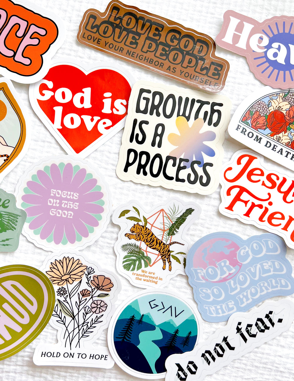 Assorted Christian stickers, including red 'God is Love' hearts and purple 'Holy' decals