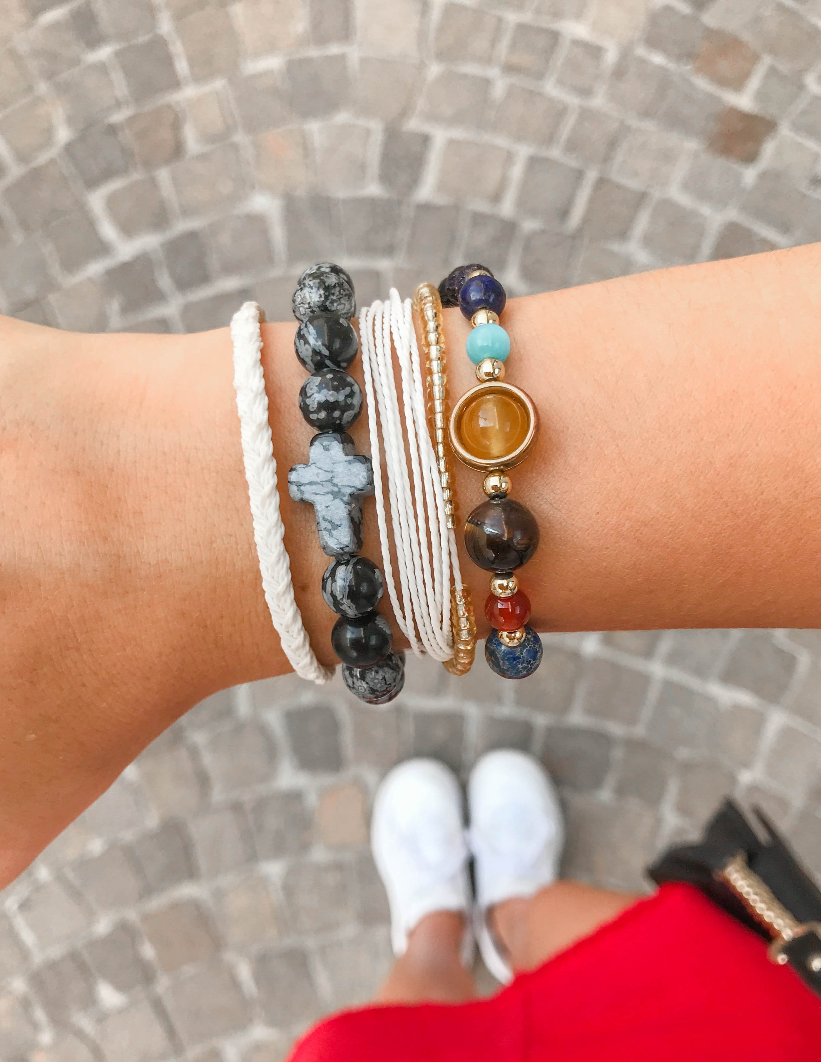 Bracelet with dark round stone beads and metal accents, worn on wrist