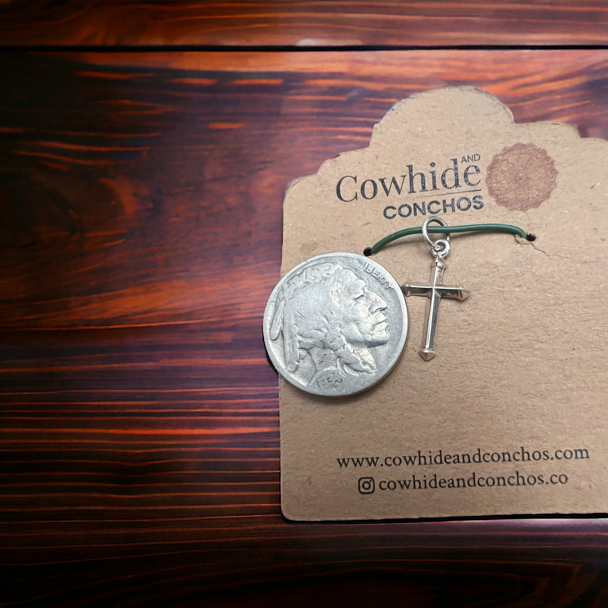Sterling silver cross charm on green cord with coin for size reference