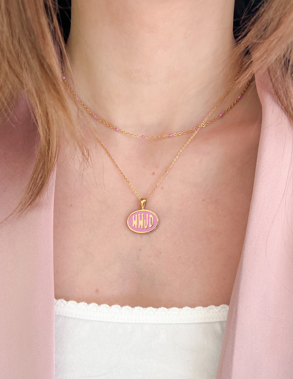 Gold-tone necklace with small pink WWJD round pendant on a short chain