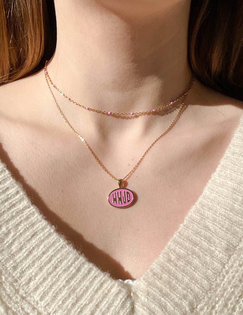 Gold-tone necklace set with pink WWJD round pendant centered at the neckline