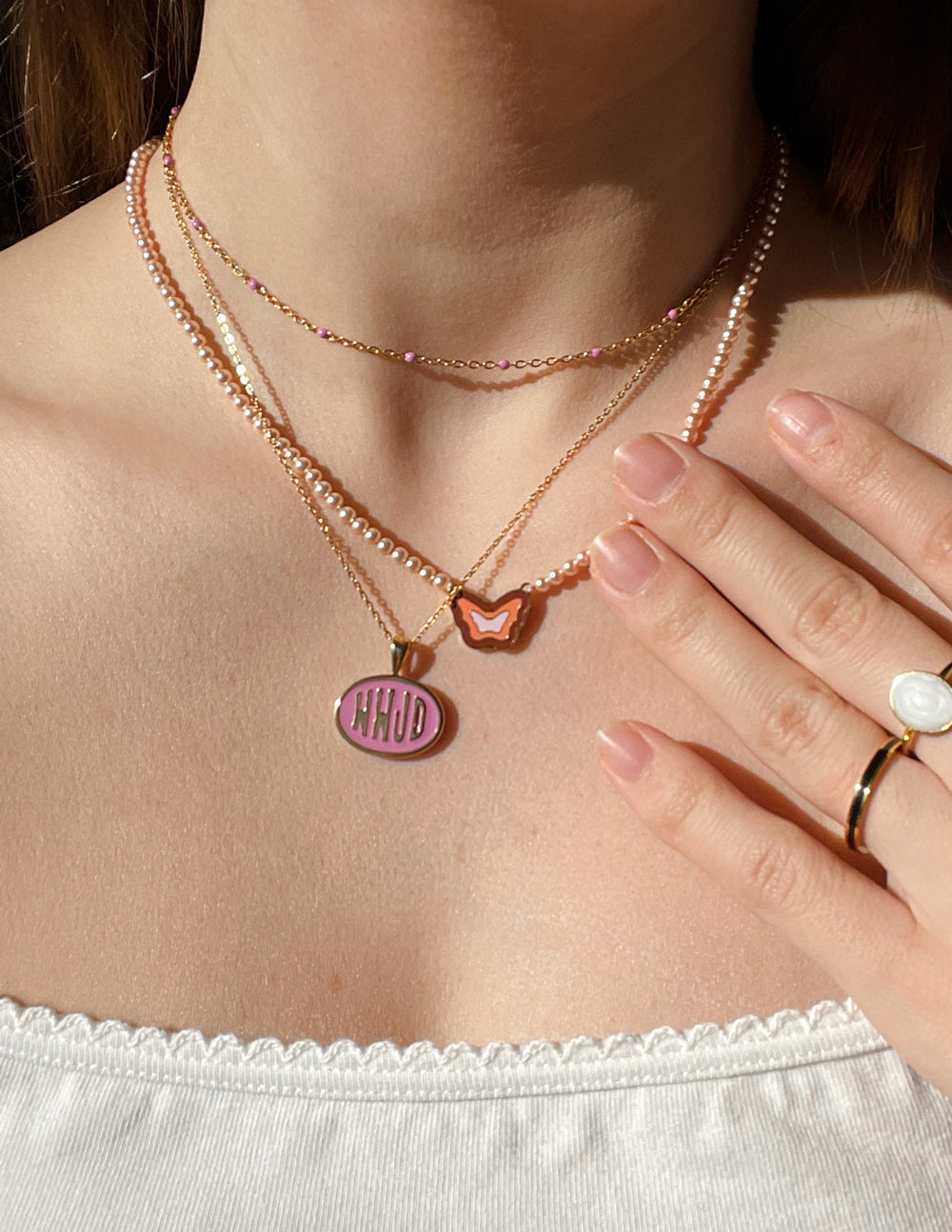 Gold-tone necklace set featuring pink WWJD round pendant and heart-shaped charm