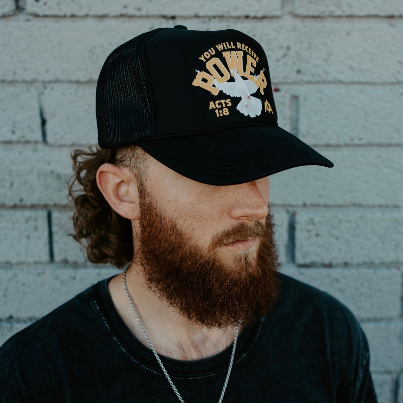 Black POWER graphic trucker cap with curved brim and mesh back, worn sideways