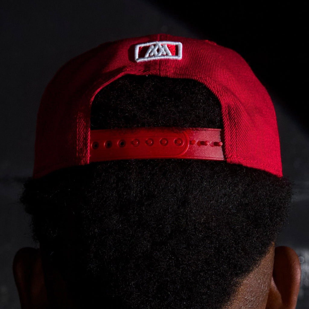 Red snapback cap with black interior and white front square logo patch