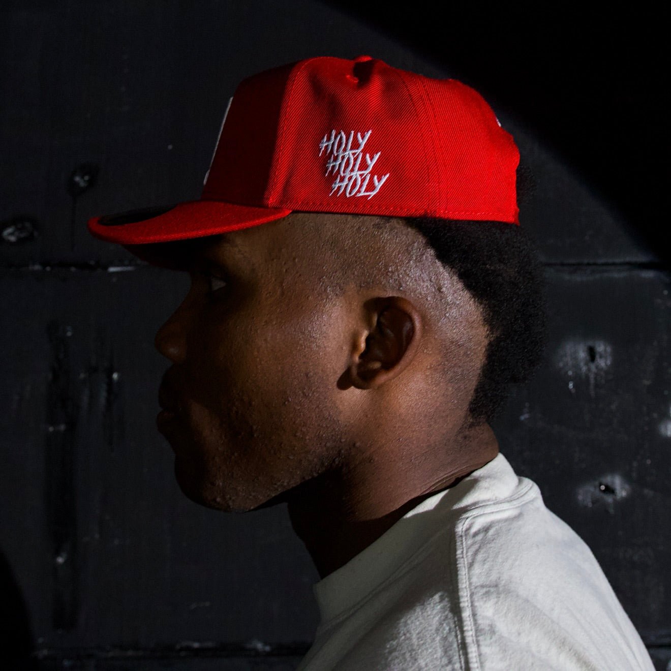 Red snapback cap with curved brim and white embroidered logo