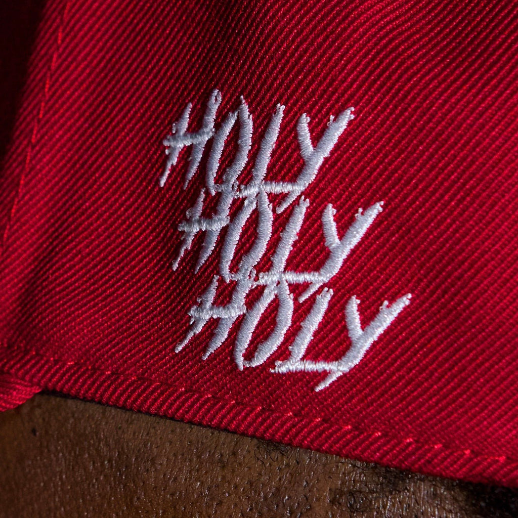 Red cap fabric close-up with white script logo on front