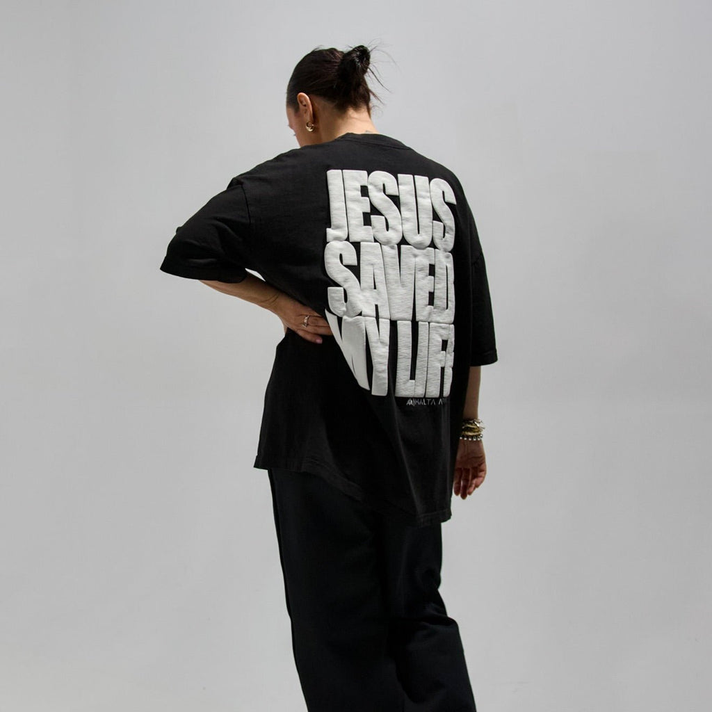 Black T-shirt back with large white puff print text: JESUS SAVED MY LIFE.