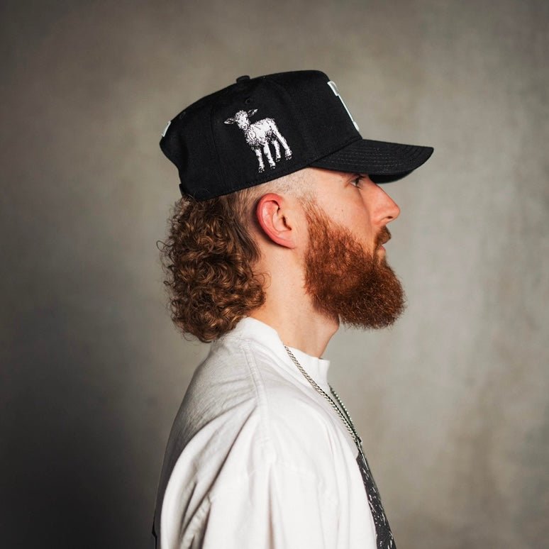 Black snapback cap with white graphic on front panel