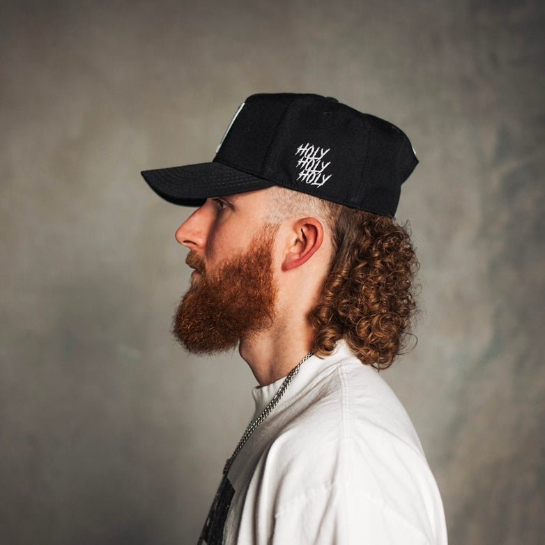 Black snapback cap with white "holy" text on side
