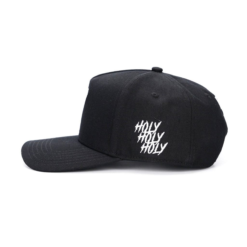 Black snapback cap with white "holy" text graphic on side