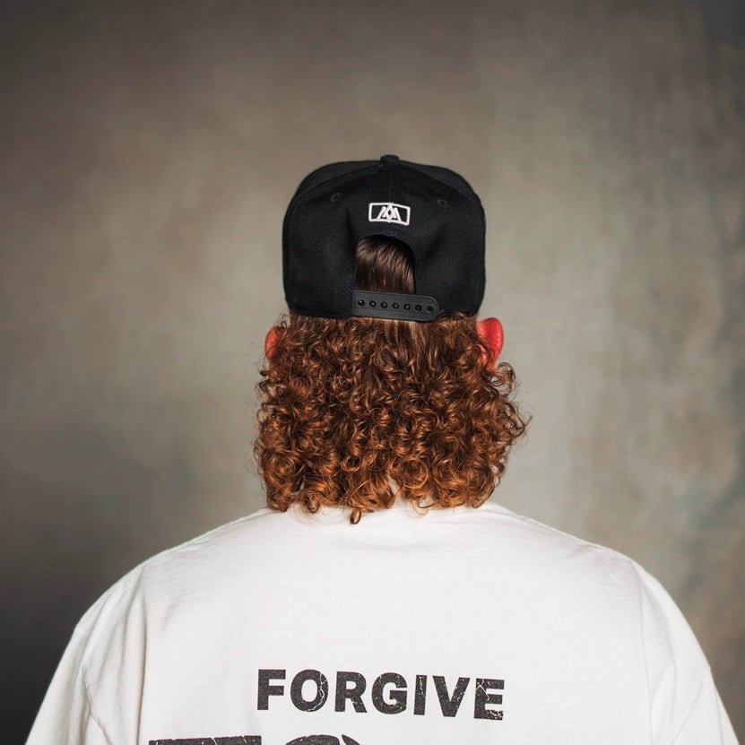 Black snapback cap with small white emblem on back
