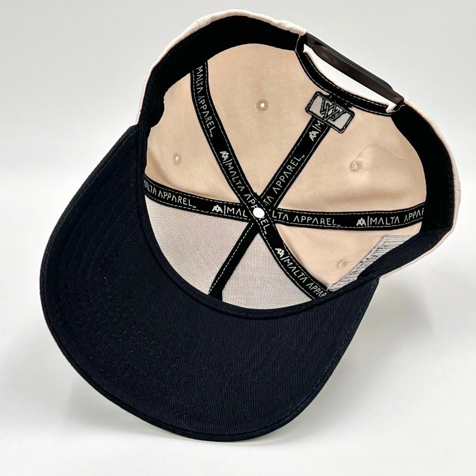 Snapback cap interior with cream lining and black underside brim, flat-lay view.