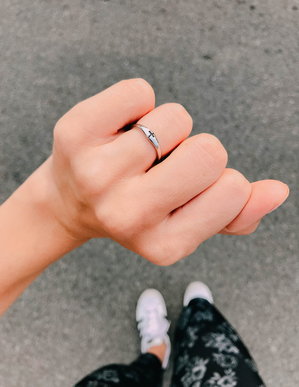 Silver promise ring on finger with 'PROMISE' lettering and small cross