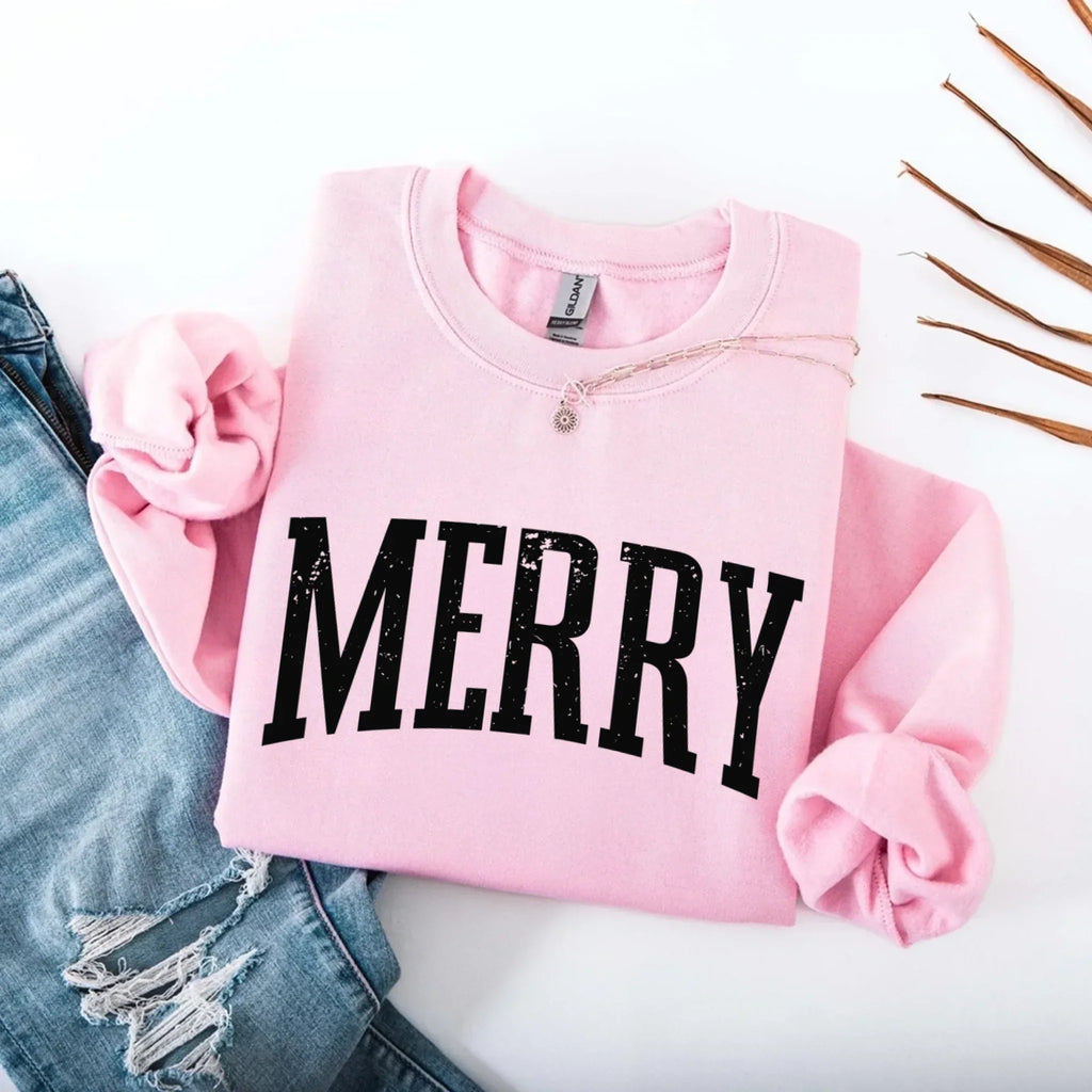 Women’s holiday sweatshirt in light pink with “MERRY” front graphic and crewneck buttons