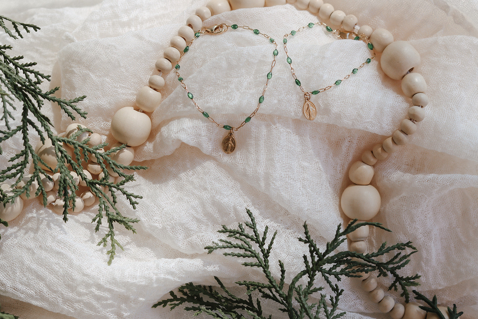Green beaded bracelet with oval medal charm and small dangling charm