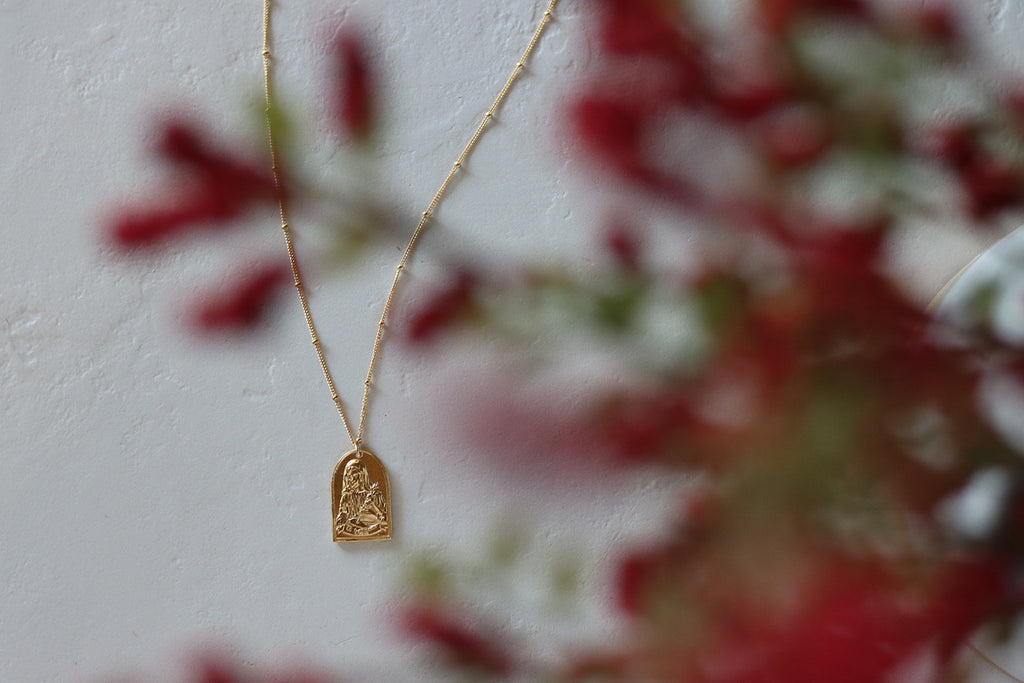Gold-tone St. Catherine pendant necklace with small arched saint charm