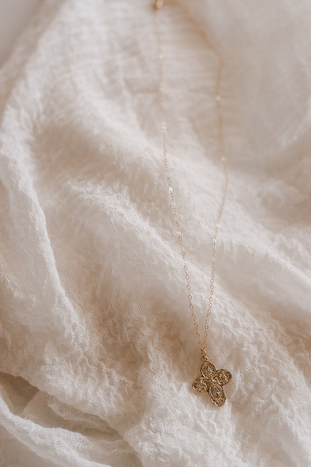 Gold-tone cross pendant necklace with delicate chain, small cross charm.