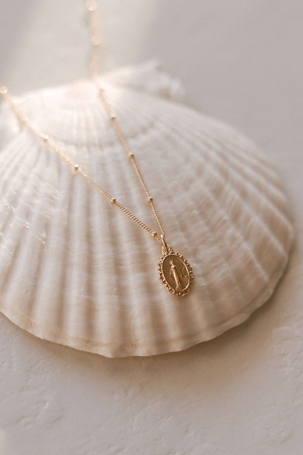 Gold-tone chain necklace with oval Miraculous medal pendant and beaded links