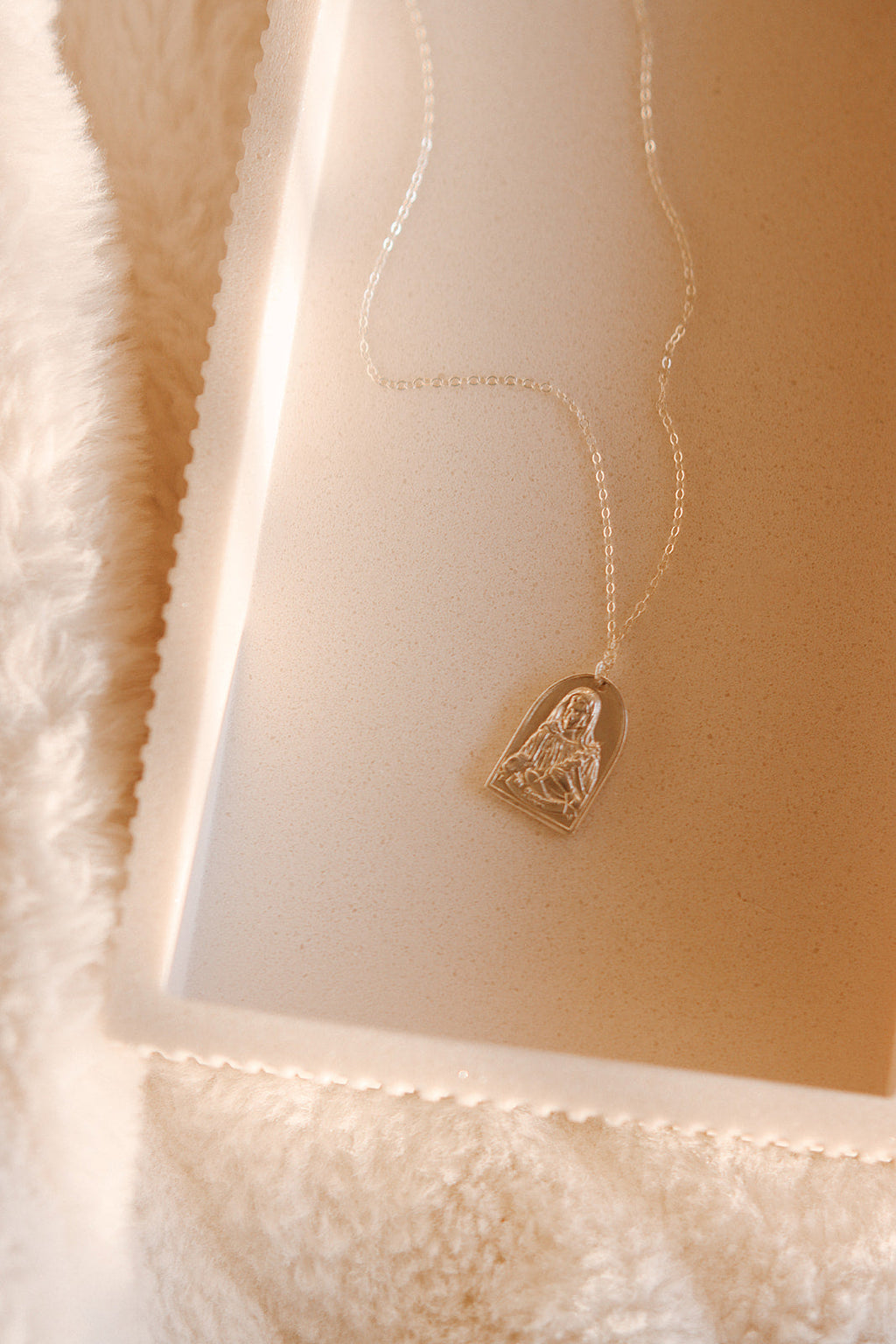 Sterling silver necklace with small heart saint pendant on a fine chain