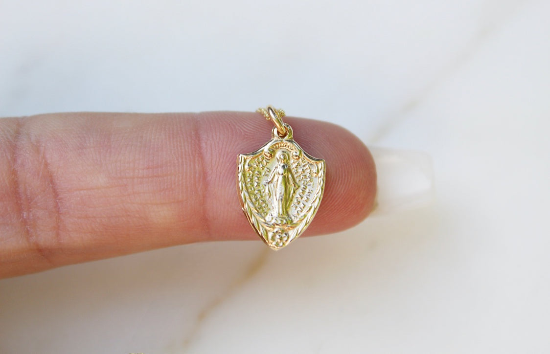 Gold-tone shield pendant with religious figure on a necklace chain