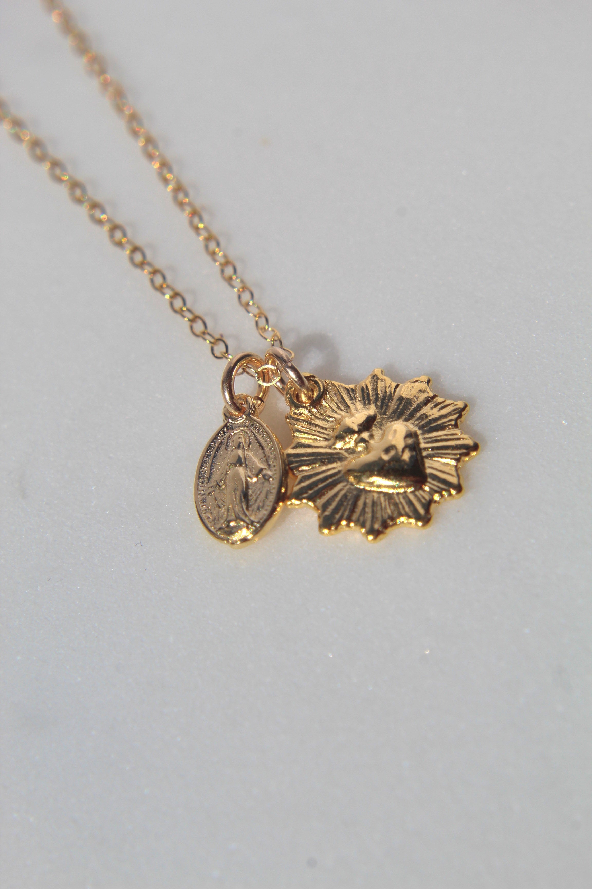 Gold-tone sacred heart and Miraculous Medal charms pendant necklace closeup