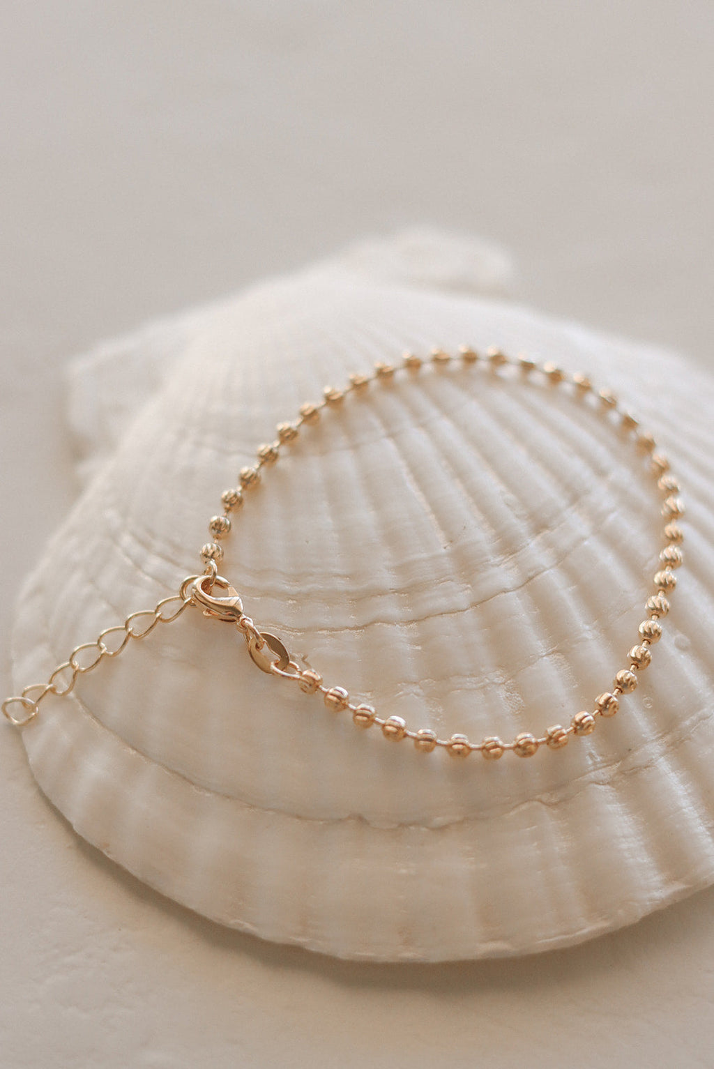 Gold-tone beaded medal charm bracelet with oval pendant and chain link strand