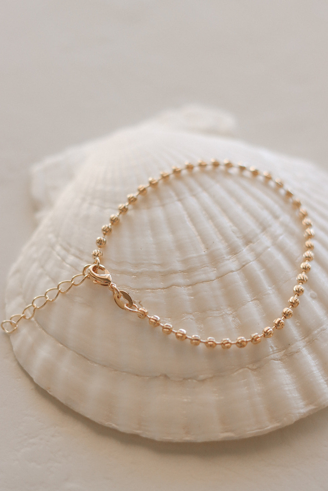 Gold-tone beaded medal charm bracelet with oval pendant and chain link strand