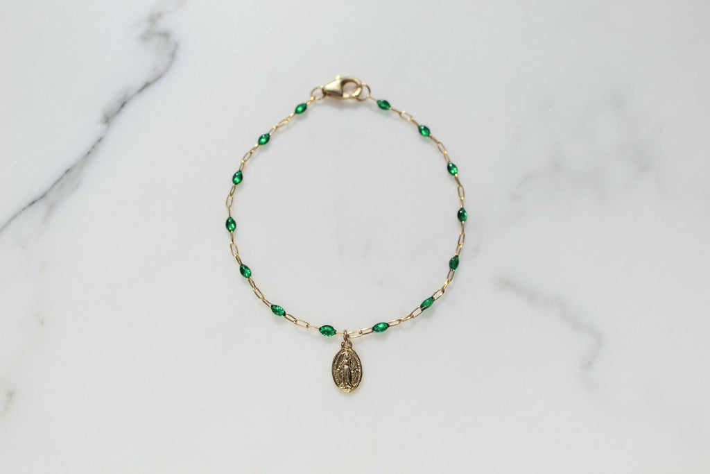 Gold-tone beaded bracelet with green teardrop beads and oval medal charm