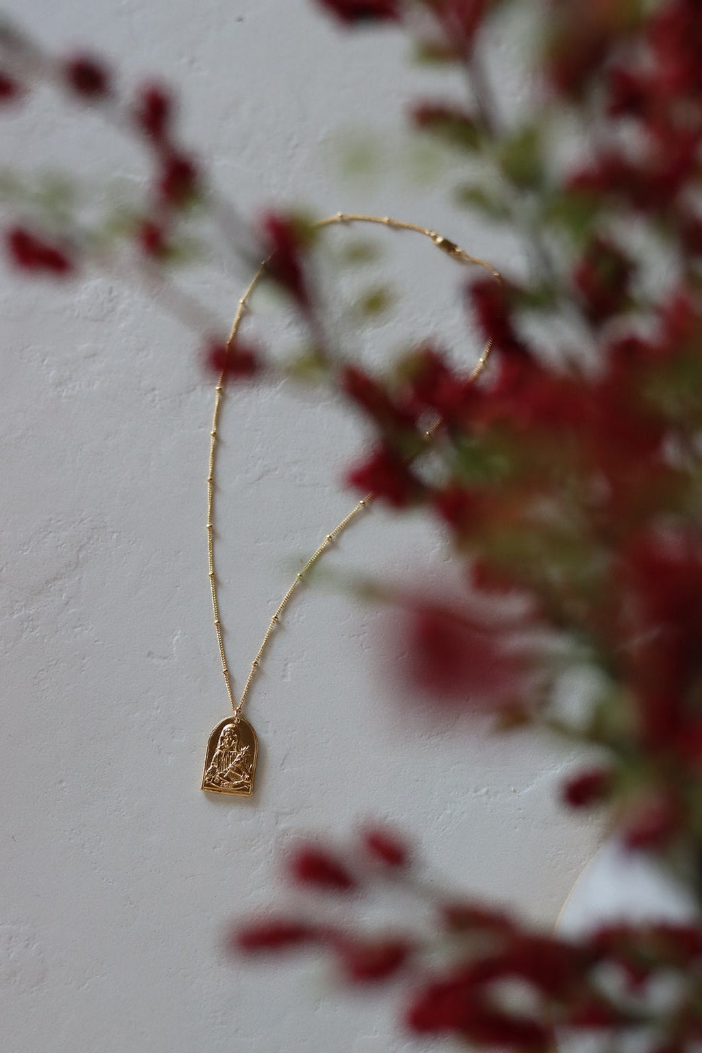 Gold-tone arched Saint pendant necklace with delicate chain