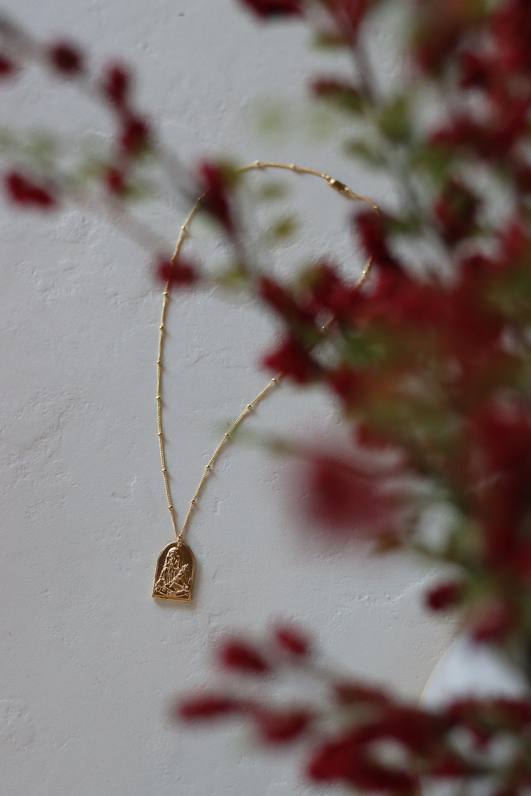 Gold-tone arched Saint pendant necklace with delicate chain