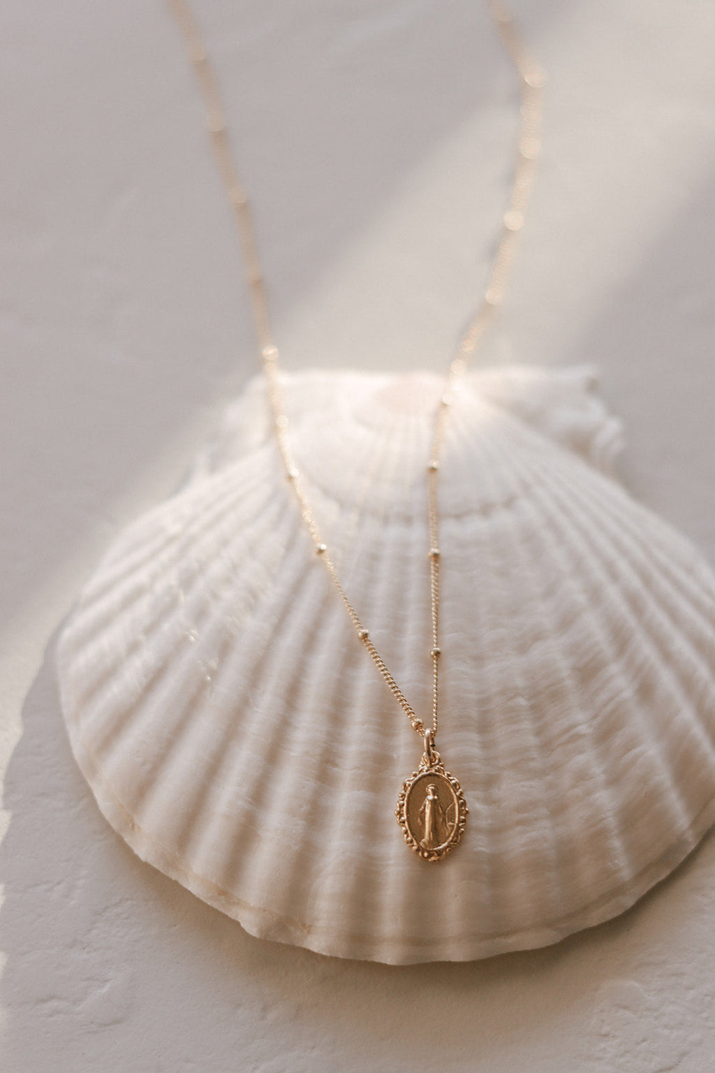 Gold-tone necklace with oval medal pendant on two layered chains