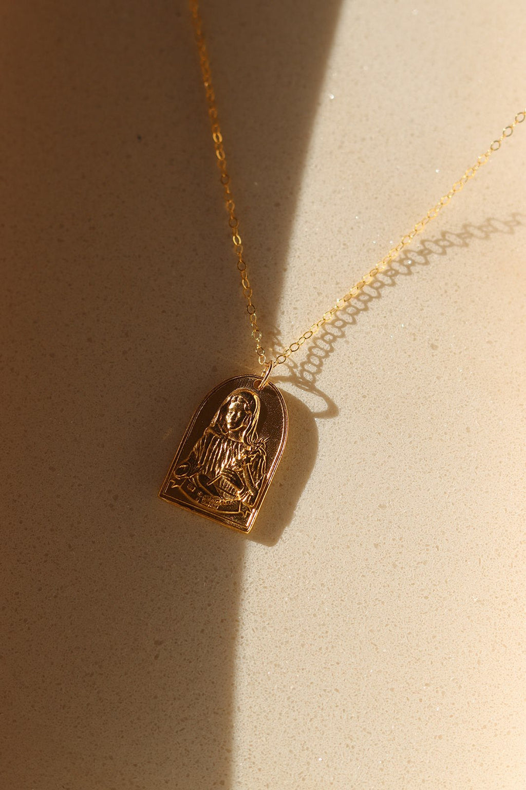 Gold-tone St. Catherine pendant necklace with arched saint charm and chain