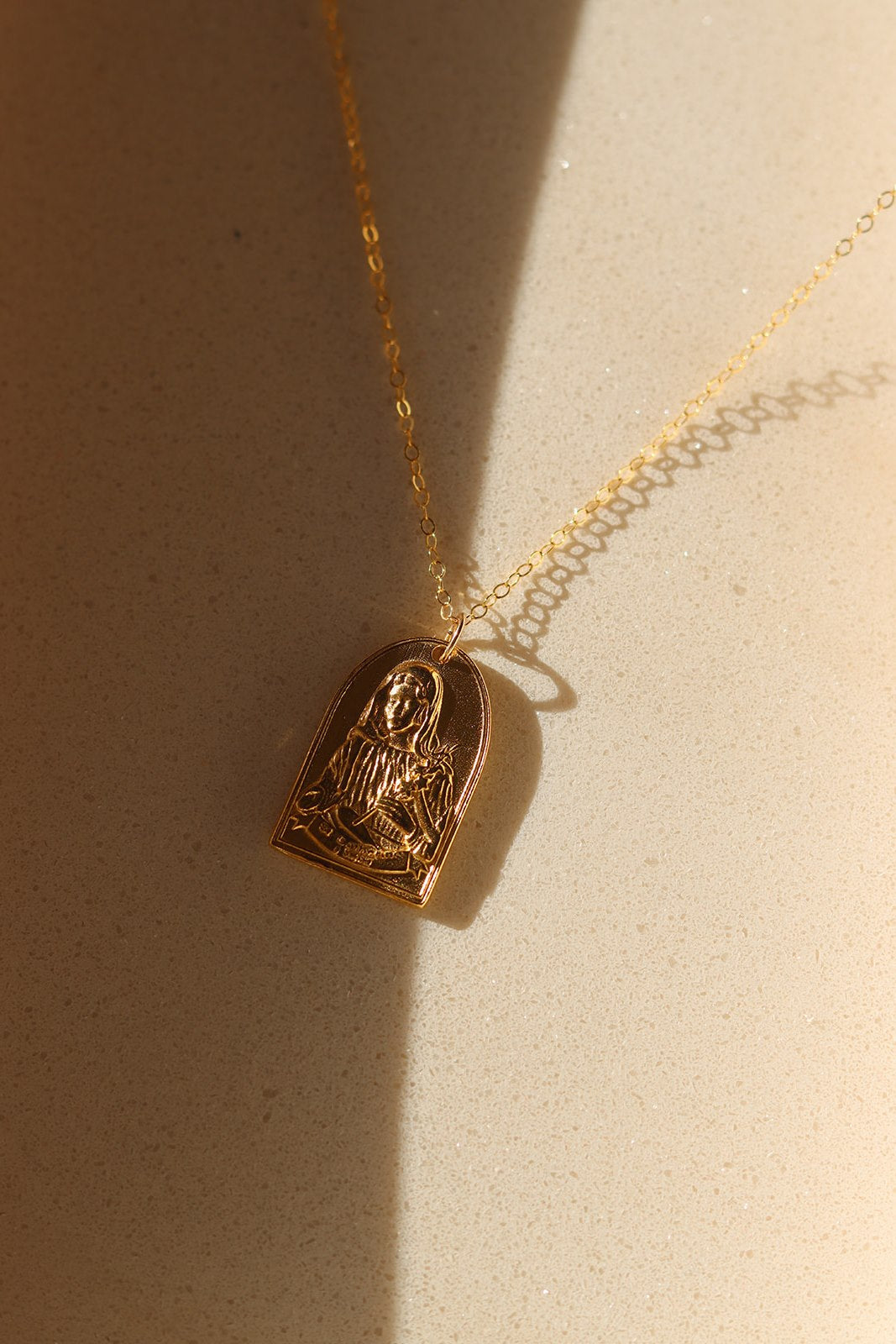 Gold-tone St. Catherine pendant necklace with arched saint charm and chain