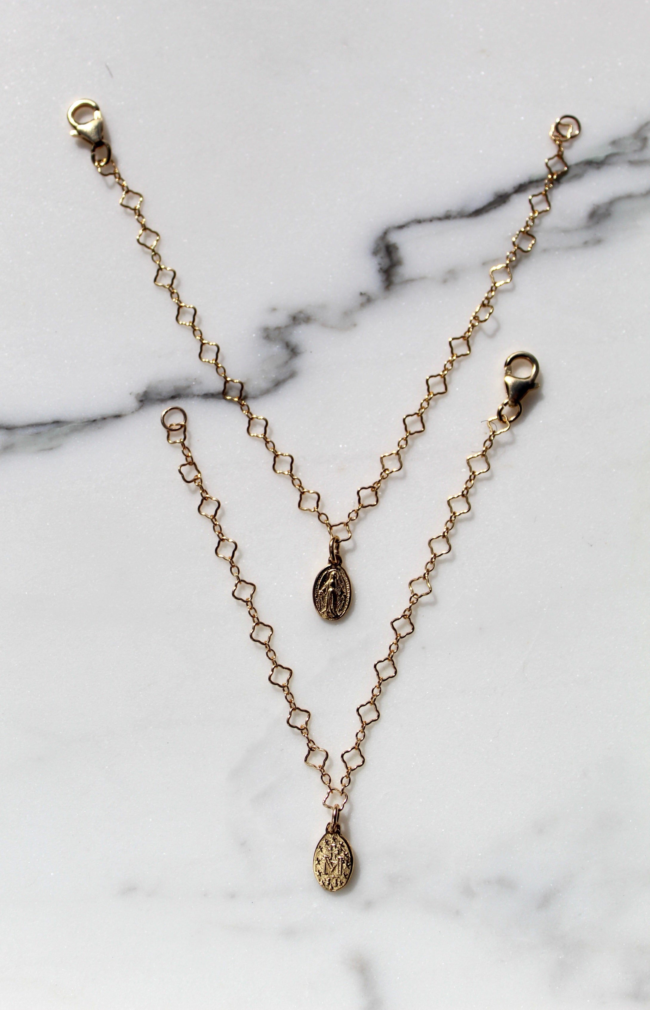Gold chain bracelet with circular medallion charms and lobster clasp