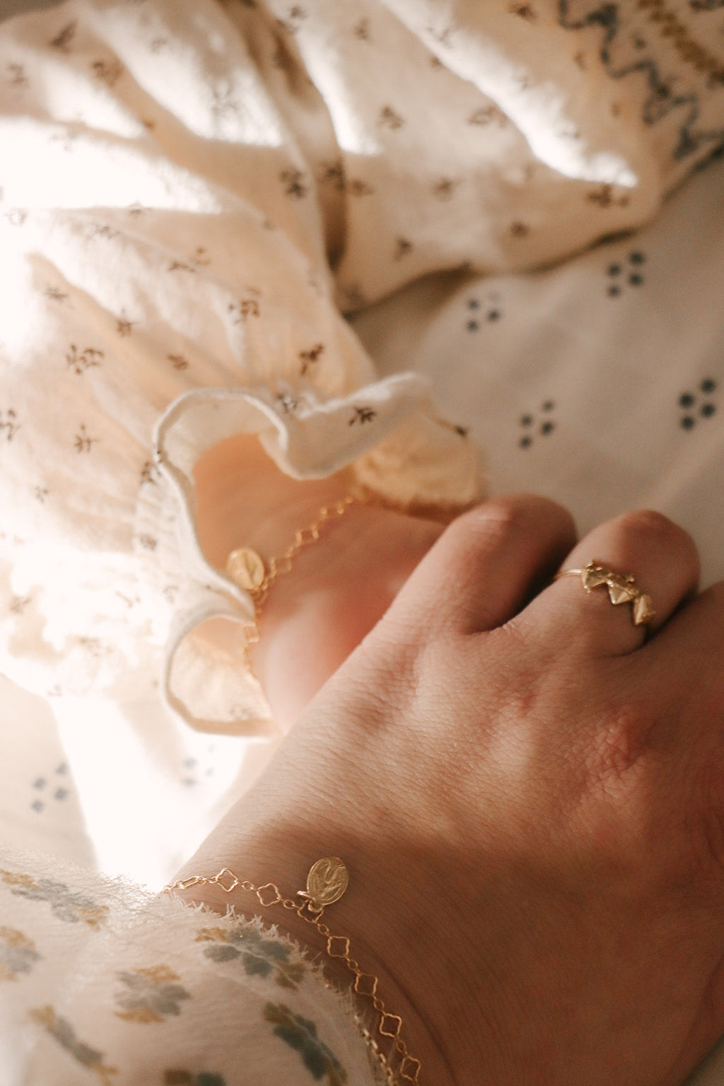 Gold chain bracelet with circular medallion charm on wrist