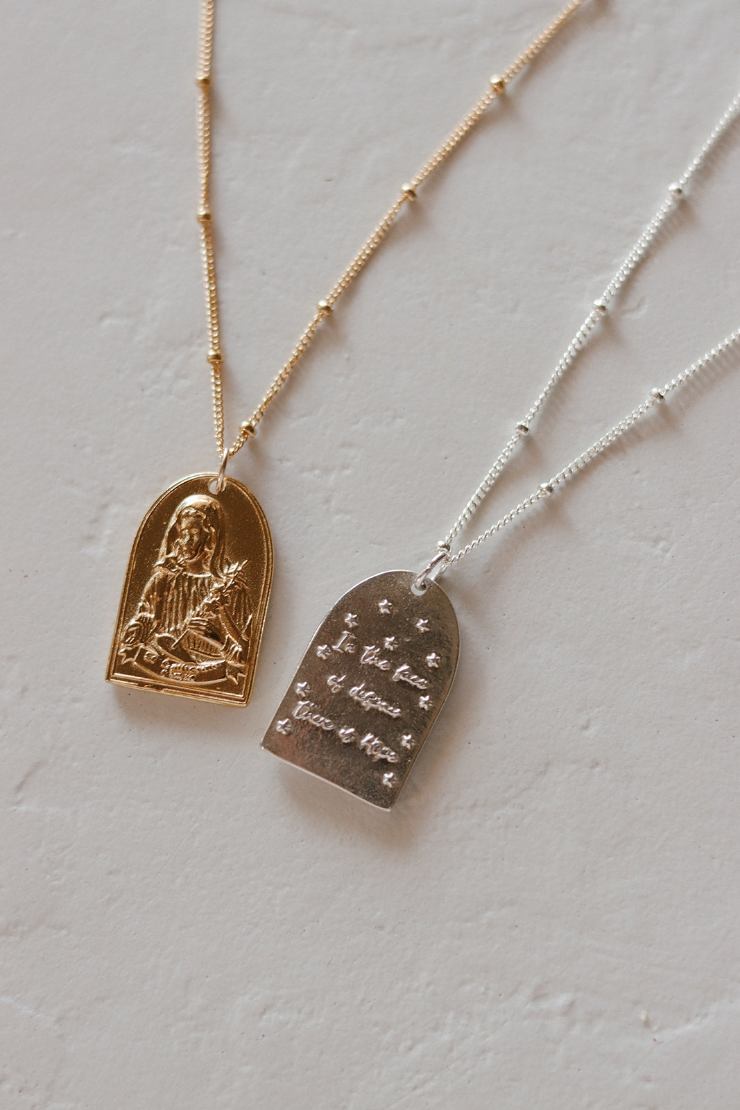 Heart pendant necklaces with saint relief: gold-tone and silver-tone on chains