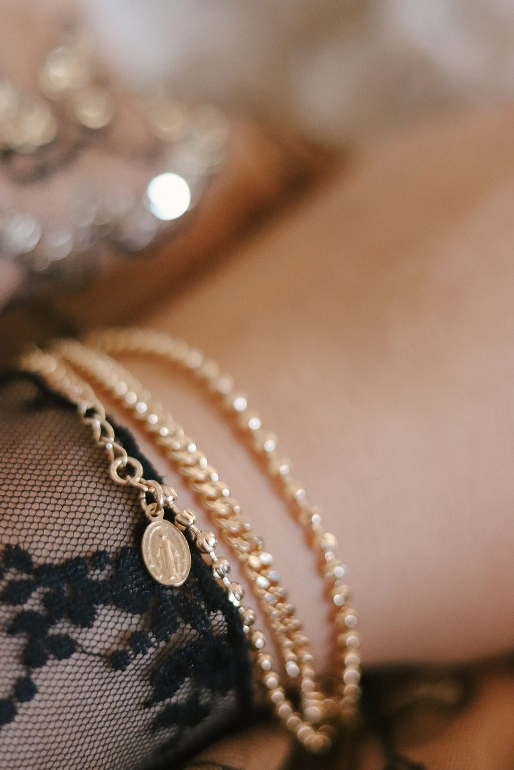 Gold-tone medal charm bracelet with oval pendant and pearl-bead strands