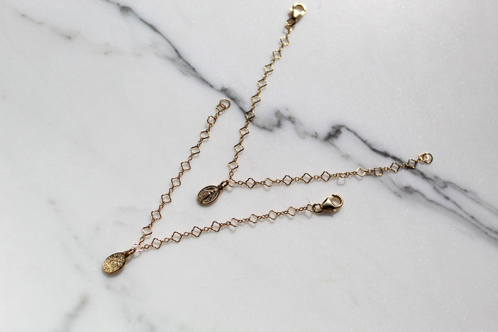 Gold chain bracelet with small circular charm medallion and clasp