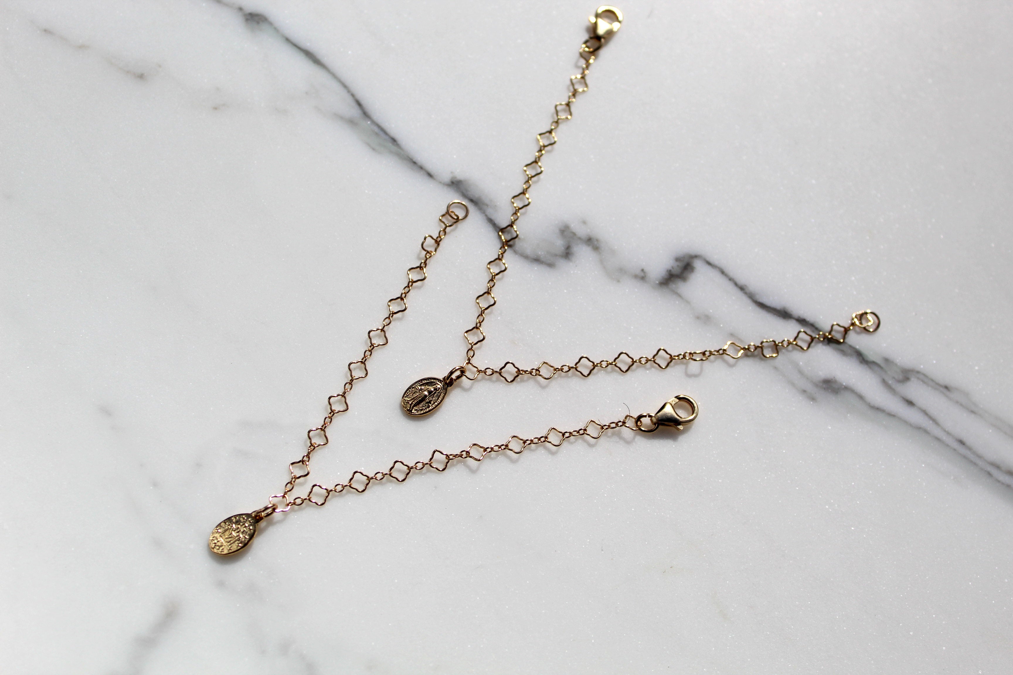 Gold chain bracelet with small circular charm medallion and clasp