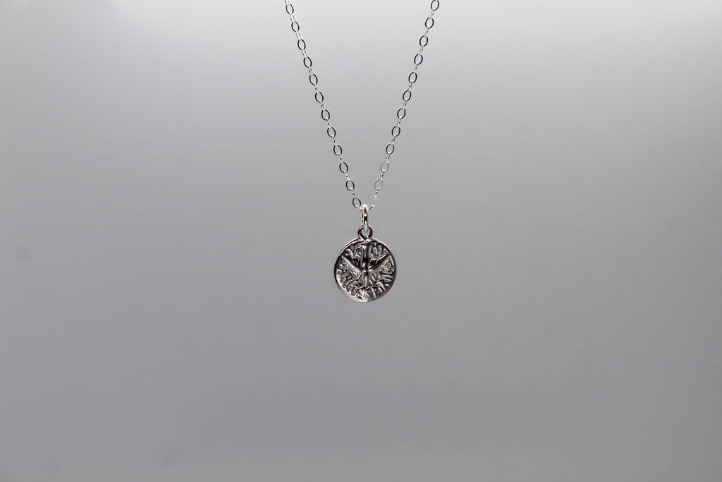 Sterling silver necklace with round Holy Spirit pendant hanging from chain