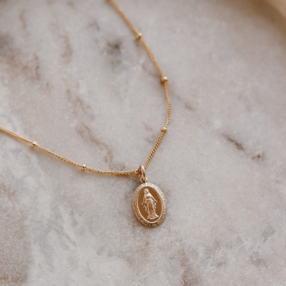 Gold-tone chain necklace with round medal pendant detail