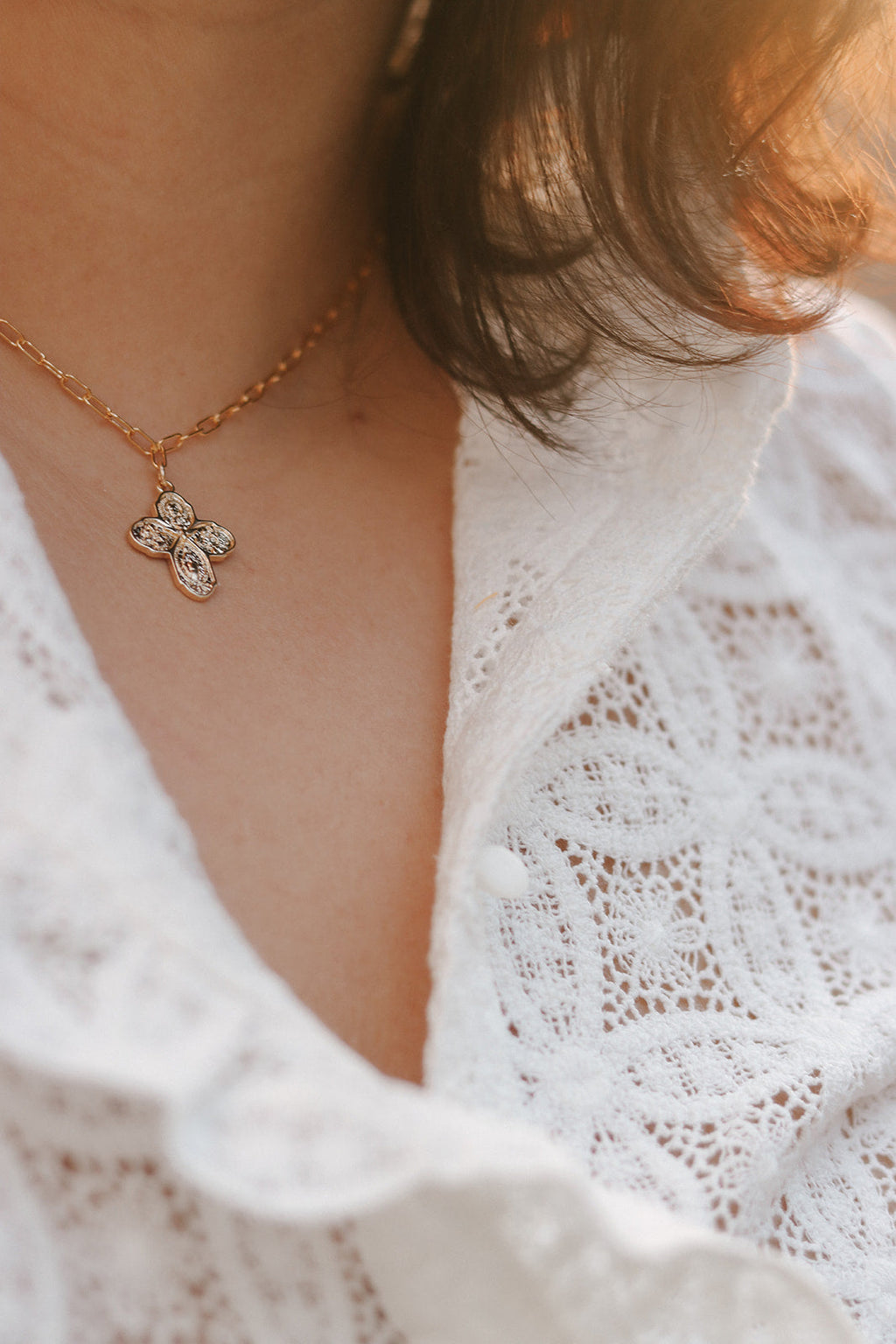 Gold cross necklace with paperclip chain and clear-stone four-way cross pendant