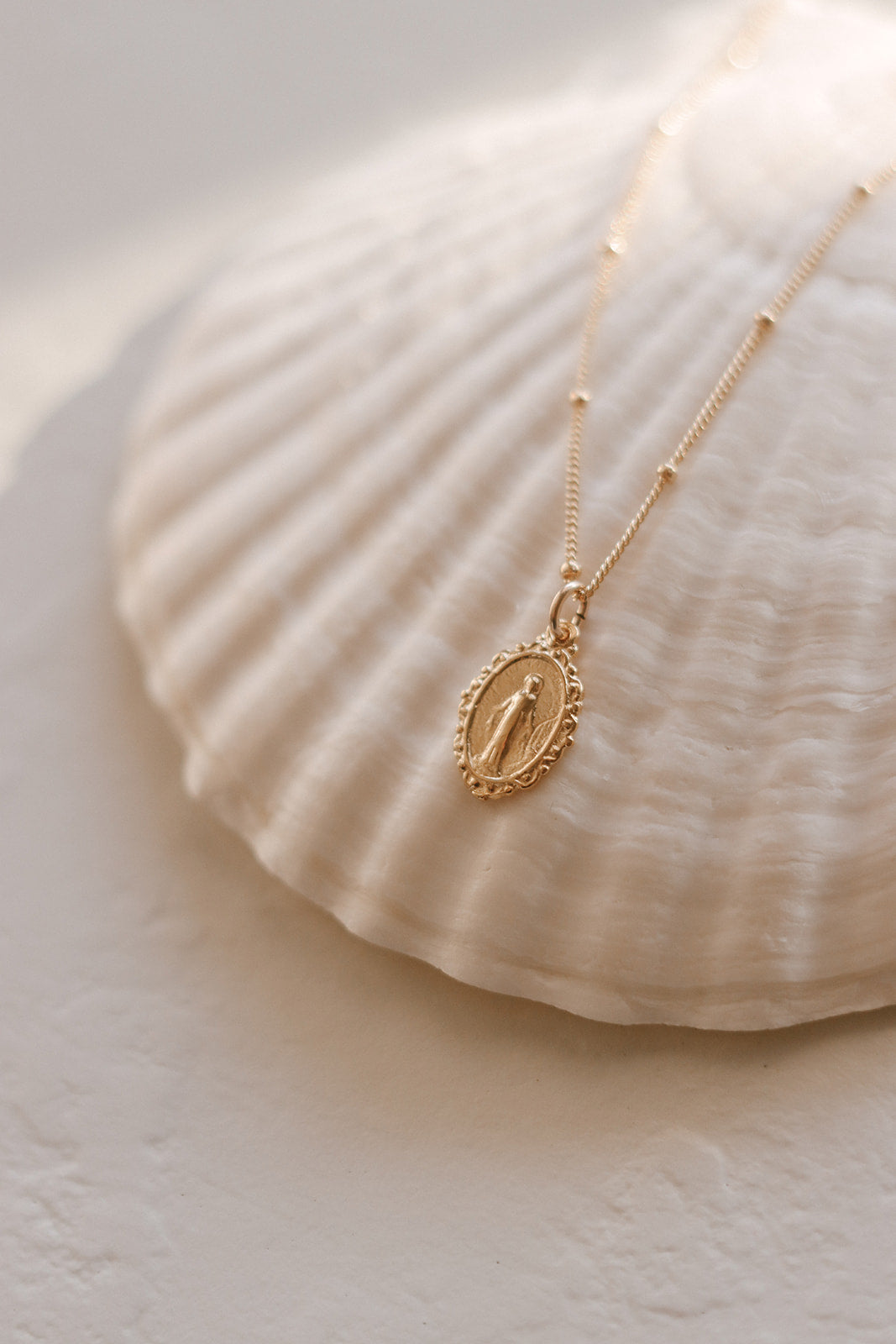 Gold-tone necklace with oval miraculous medal pendant on a fine chain