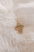 Gold cross necklace with large textured cross pendant on a thin chain