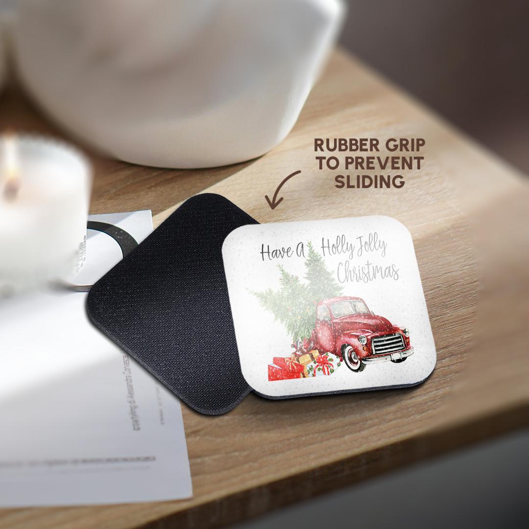 Black coaster mat holding a round coaster with red truck, holly, and 'Have a Holly Jolly Christmas'