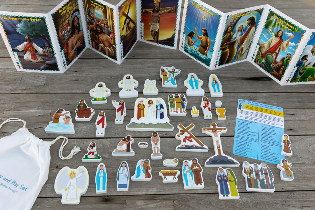 Rosary play set pieces with standing figures, crosses, and illustrated card panels plus bag